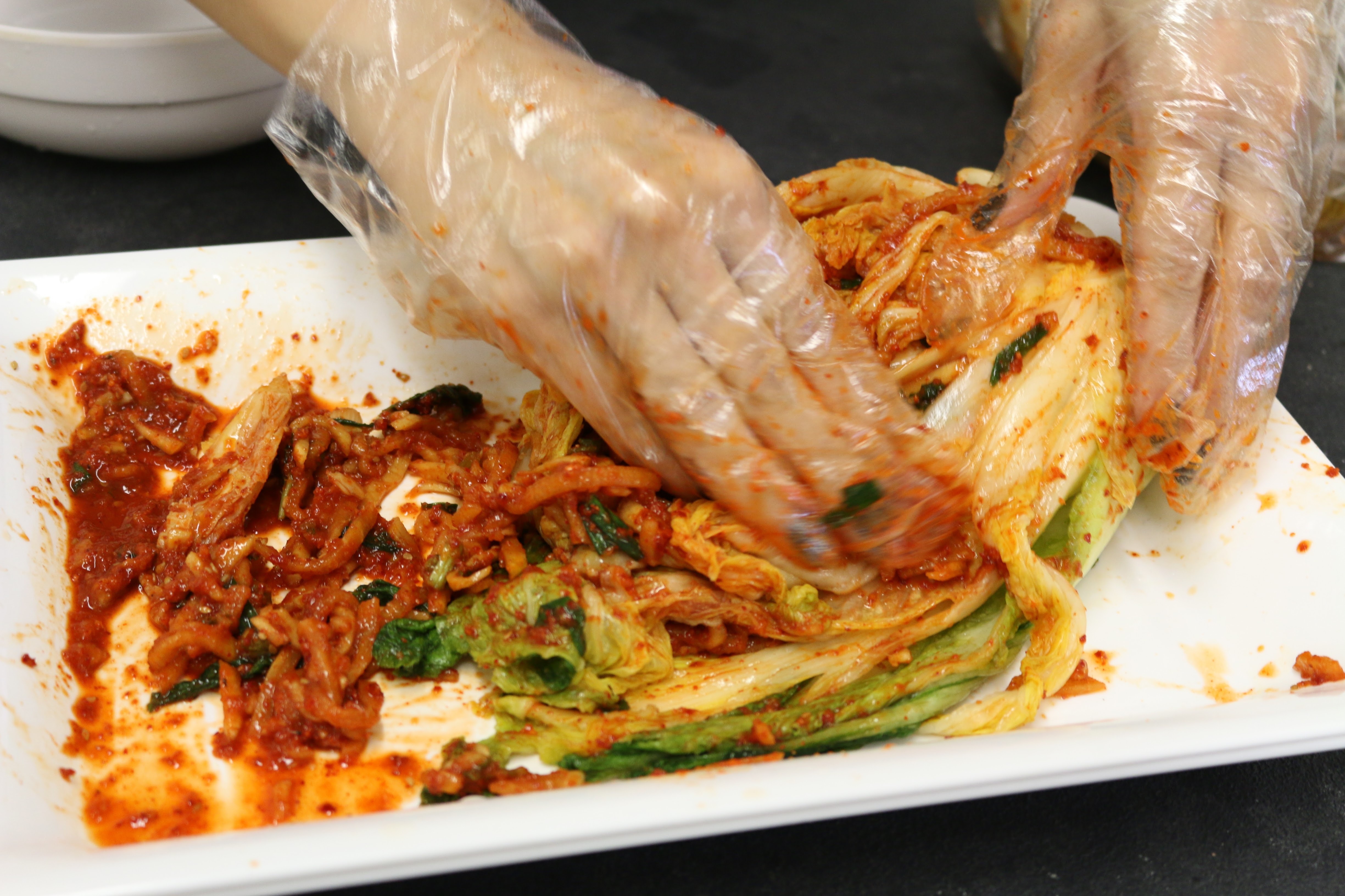 With gloves on, generously apply onto each leaf of the cabbage with the seafood paste.